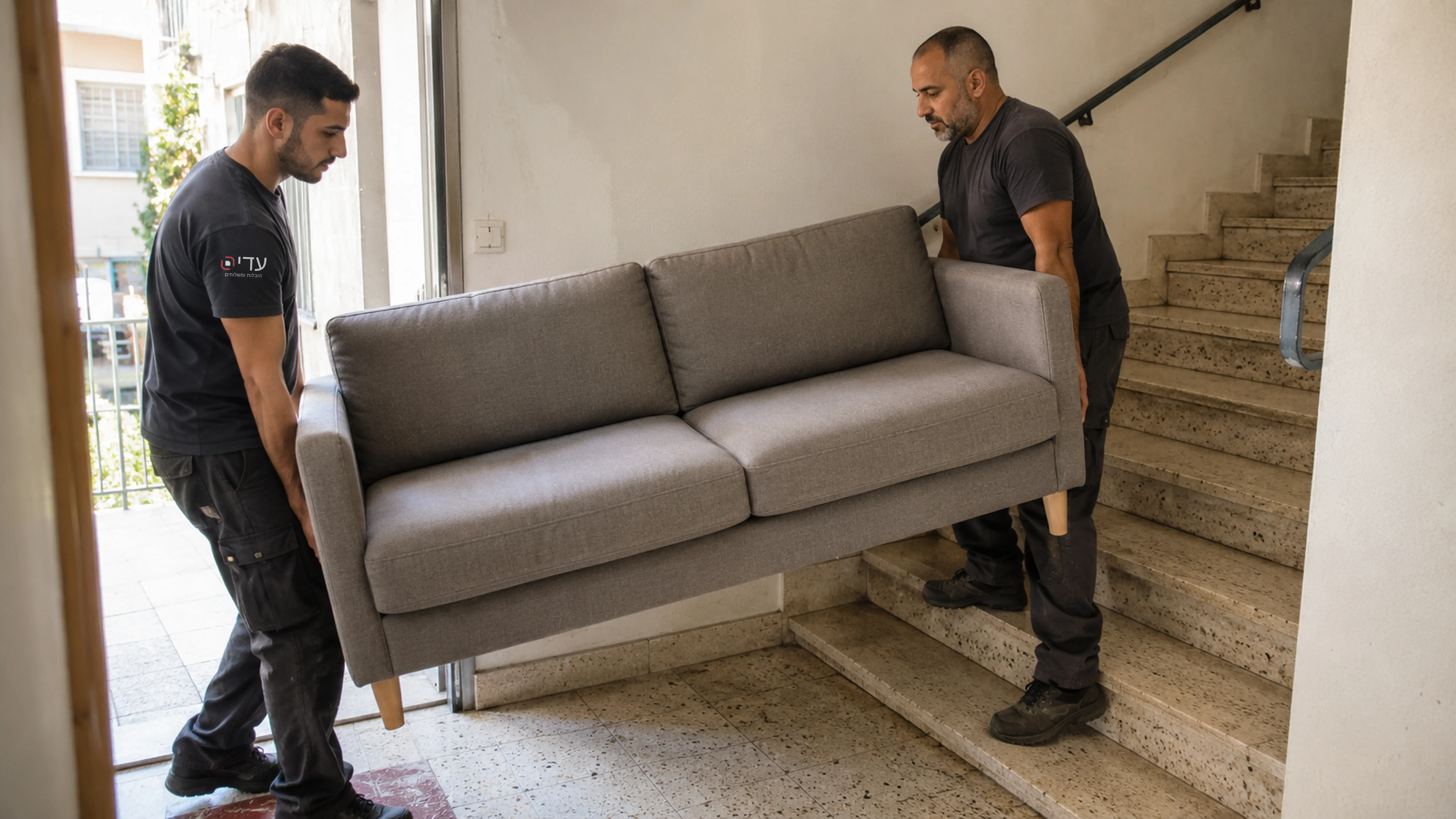 שני מובילים נושאים ספה בזהירות בחדר מדרגות